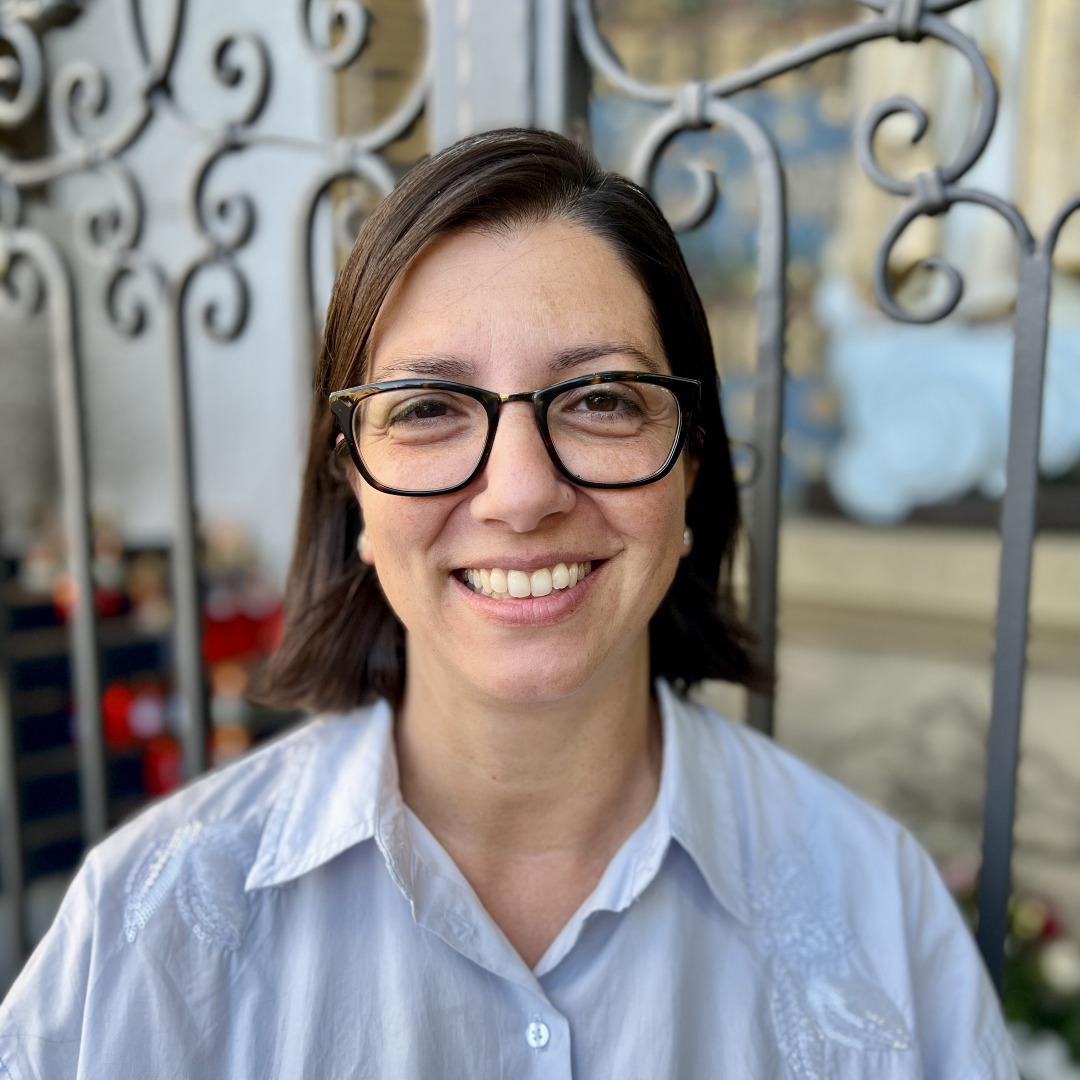 Carmela Tassone, lachende Frau mit Brille und kurzen dunklen Haaren